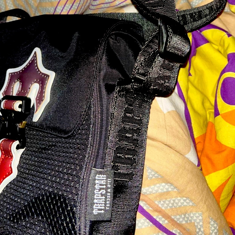 Trapstar brand new side bag with the red and black shade on the logo